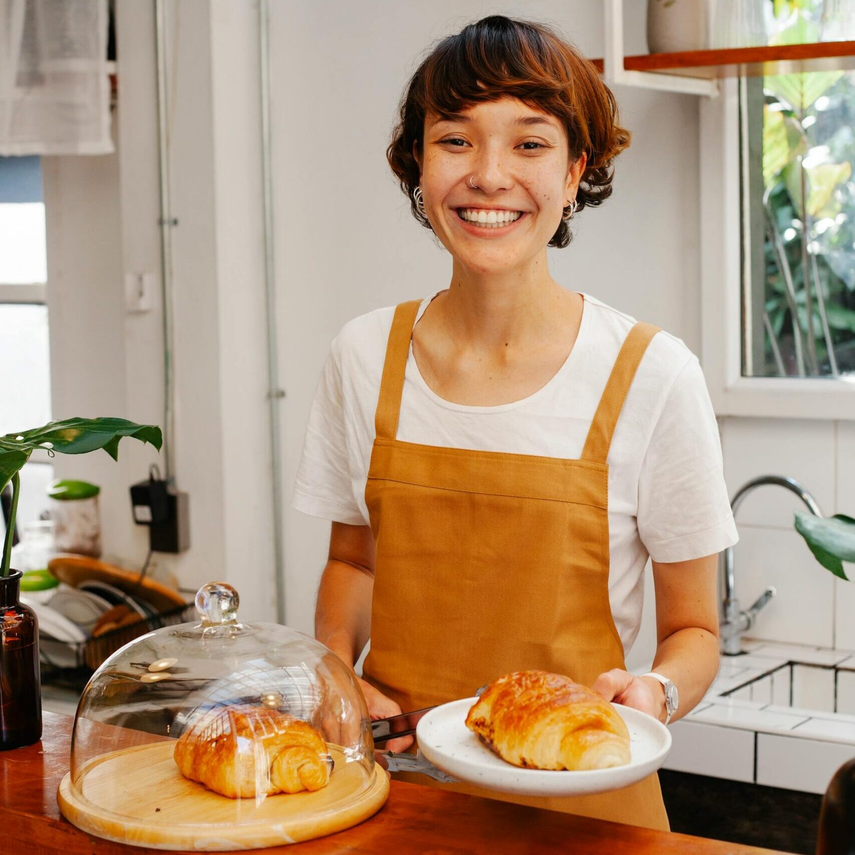 Smiling woman serving a croissant